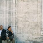 Senior couple sitting by the New Mosque in Eminönü, Istanbul, reflecting a moment of leisure.