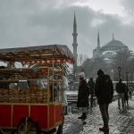 People buying food from a cart in snowy istanbul