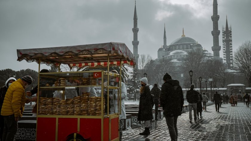 People buying food from a cart in snowy istanbul