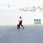 Person with suitcase walking in Kabataş, Istanbul, Türkiye, showcasing urban lifestyle and modern architecture.
