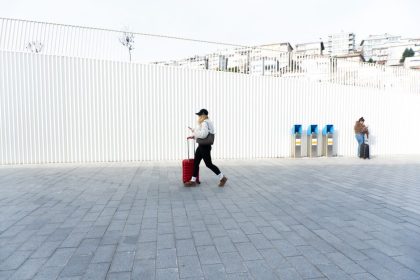 Person with suitcase walking in Kabataş, Istanbul, Türkiye, showcasing urban lifestyle and modern architecture.