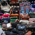 a pile of purses and handbags sitting next to each other