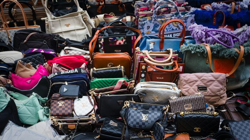 a pile of purses and handbags sitting next to each other