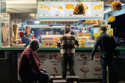 a group of people standing in front of a food stand