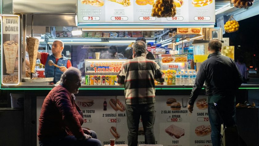 a group of people standing in front of a food stand