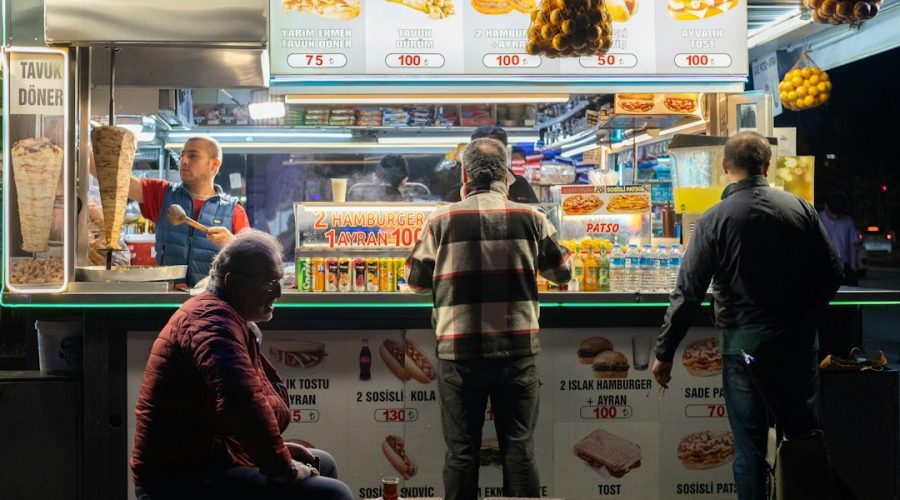 a group of people standing in front of a food stand